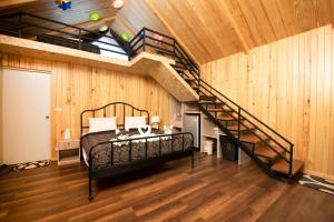 een slaapkamer met een bed en een wenteltrap bij Mont Blanc Glamping Khao Yai in Mu Si
