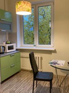 a kitchen with a chair and a table and a window at Happy Day in Narva