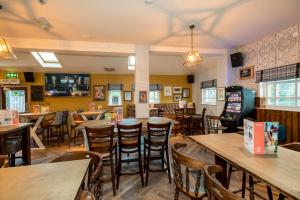 a restaurant with tables and chairs in a room at Wee Waif by Greene King Inns in Reading +26 photos
