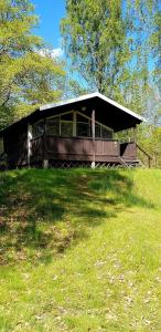 ein großes Holzhaus auf einem Grasfeld in der Unterkunft Kolleviks Camping och Stugby in Karlshamn