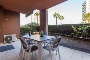 un patio con mesa de comedor y sillas en MUSSULO BEACH APARTMENT litoralmar, en Portimão