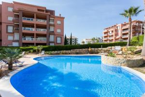 a large blue swimming pool in front of a building at MUSSULO BEACH APARTMENT litoralmar in Portimão