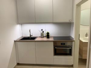 una cocina con armarios blancos y fregadero en Appartement Höhscheid, en Solingen