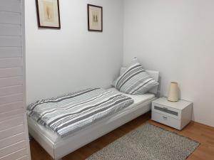 1 dormitorio con 1 cama blanca con mesita de noche y 1 cama sidx sidx sidx sidx en Appartement Höhscheid en Solingen