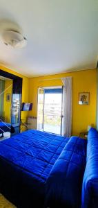 Un dormitorio con una gran cama azul y una ventana en Casa degli Aranci, en Sorrento