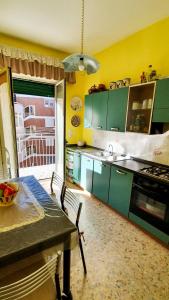 una cocina con armarios verdes y una mesa con mesa en Casa degli Aranci, en Sorrento