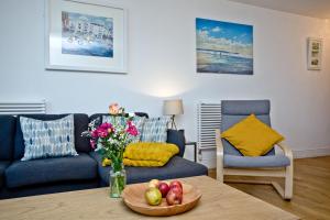 a living room with a table with a bowl of fruit at 5 At The Beach in Beesands