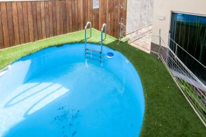 una piscina en un patio con césped en Gandia Confort Treviso en Gandía