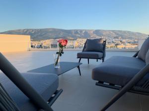 a living room with two chairs and a vase with flowers on a table at Kolonaki Terrace in Athens