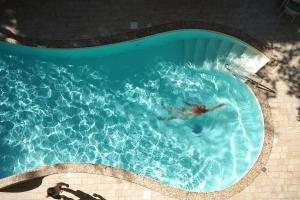 un hombre nadando en una piscina en Hotel Pineta en Bellaria-Igea Marina