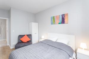 sypialnia z łóżkiem i pomarańczową poduszką w obiekcie Chill Apartments Harmony Park Ursynów w Warszawie