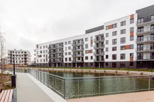szereg budynków apartamentowych obok rzeki w obiekcie Chill Apartments Harmony Park Ursynów w Warszawie