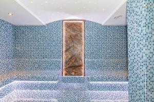 a bathroom with a shower with blue tiles at Bekdas Hotel Deluxe & Spa in Istanbul