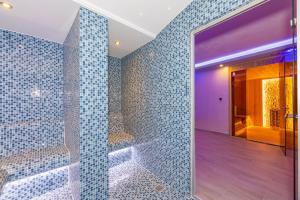 a bathroom with a shower with blue tiled walls at Bekdas Hotel Deluxe & Spa in Istanbul