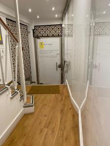 um quarto com um chuveiro e uma porta de vidro em Catedral Boutique em Sevilha