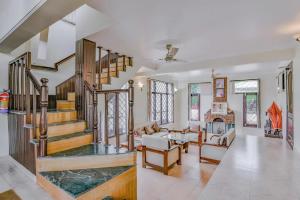 a large living room with a staircase and a living room at Karinya Villas in Nainital