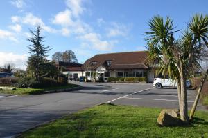 een witte auto geparkeerd voor een gebouw bij Farmhouse Innlodge by Greene King Inns in Portsmouth