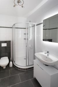 a white bathroom with a shower and a sink at Ferienwohnungen am Markt - Der Sachsenhof in Bad Liebenwerda