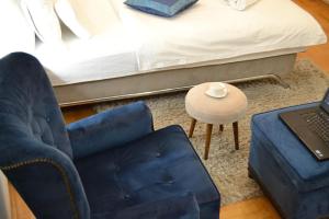 una camera da letto con sedia blu e un letto con computer portatile di Apartment CRYSTAL a Banja Luka
