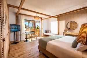 a hotel room with a bed and a television at Stella Island Luxury Resort & Spa (Adults Only) in Hersonissos