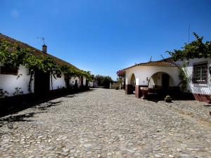 a cobblestone street in a village with white houses at Monte das Oliveiras in Arraiolos