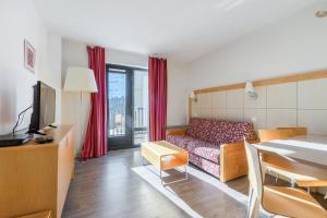 a small living room with a bed and a table at Residence La Foret - maeva Home in Arâches-la-Frasse
