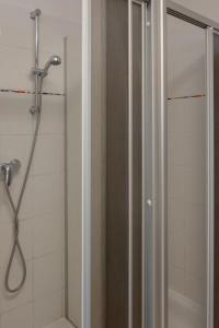 a shower with a glass door in a bathroom at Hostel Louise 20 in Dresden
