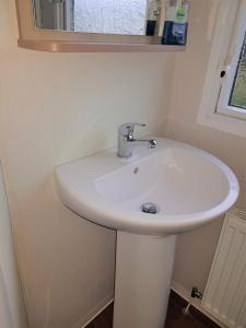 a white sink in a bathroom with a mirror at 720 Holiday Resort Unity, Brean in Brean