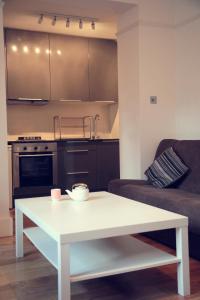 a living room with a white table and a kitchen at Flat1 Camden Road in London