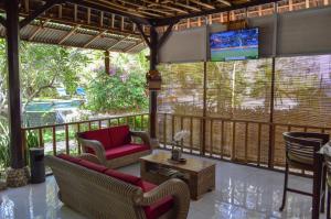 - une terrasse couverte avec des chaises et une télévision dans l'établissement Tarzan Marriott On Penida, à Nusa Penida