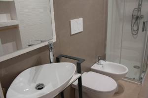bagno con lavandino bianco e servizi igienici di La Torre GMA Tourism a Torre Lapillo