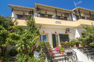 a house with flowers in front of it at Aggeliki apartments Dassia By Hotelius in Kato Korakiana