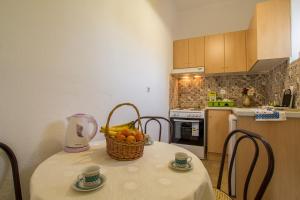 a kitchen with a table with a basket of fruit on it at Aggeliki apartments Dassia By Hotelius in Kato Korakiana +14 photos
