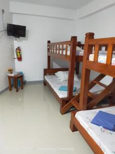 two bunk beds in a room with a flat screen tv at Jay Henry Transient Beach house, B Pagudpud, BLUE LAGOON BEACH in Pagudpud