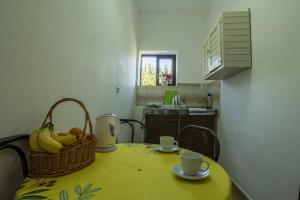 a table with a basket of fruit and two cups at Aggeliki apartments Dassia By Hotelius in Kato Korakiana