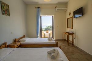 a hotel room with two beds and a window at Aggeliki apartments Dassia By Hotelius in Kato Korakiana