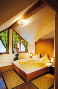 a person standing in a bedroom with a large bed at Tonis Appartements am Achensee in Achenkirch