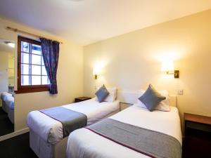 a hotel room with two beds and a window at Longforgan Coaching Inn in Dundee