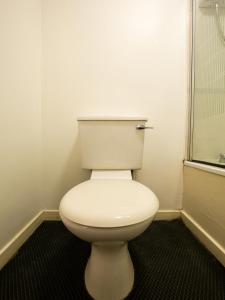 
a white toilet sitting in a bathroom next to a window at Longforgan Coaching Inn in Dundee
