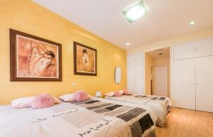 una camera con 2 letti con cuscini rosa di M&F FUENCARRAL a Madrid