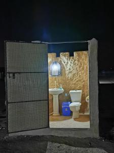 a bathroom with a toilet and a sink at Desert Wonders Camp in Ḩawīyah