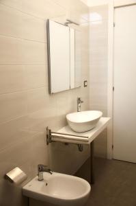 een witte badkamer met een wastafel en een spiegel bij Punta Prosciutto GMA Tourism in Porto Cesareo