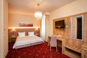 sypialnia z łóżkiem, biurkiem i telewizorem w obiekcie Grein Hotel w mieście Rzeszów +35 zdjęć