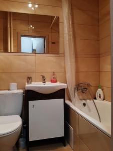 ein Badezimmer mit einem Waschbecken, einem WC und einer Badewanne in der Unterkunft Sobieskiego in Skierniewice