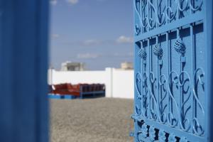 una puerta de hierro azul con un parque infantil al fondo en Ras Al Hadd Orchid en Al Ḩadd