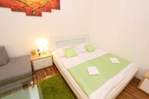 ein kleines Schlafzimmer mit einem Bett und einem Stuhl in der Unterkunft Apartment Simmering in Wien