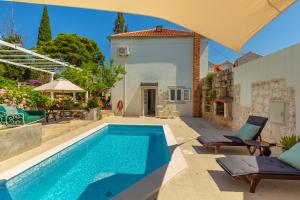 a house with a swimming pool in a yard at Villa Pomalo in Zaton