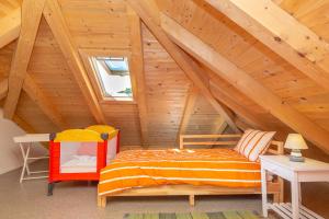 1 dormitorio en el ático con 1 cama y techo de madera en Villa Pomalo, en Zaton