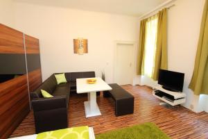 ein Wohnzimmer mit einem Sofa und einem Tisch in der Unterkunft Apartment Simmering in Wien