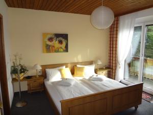 - une chambre avec un lit doté de draps blancs et d'oreillers jaunes dans l'établissement Haus Christine Aigen-Schlägl - Große Mühl, à Aigen im Mühlkreis